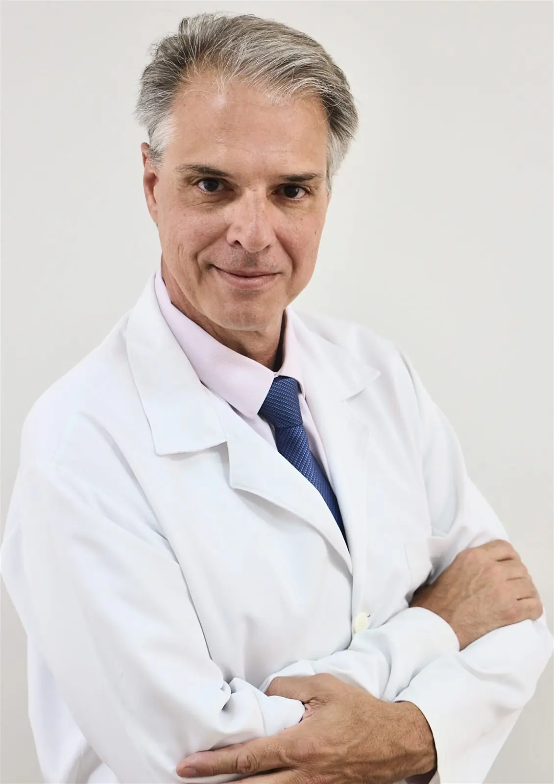 Prof. Me. Nivaldo Vanni, cirurgião-dentista, de jaleco e braços cruzados